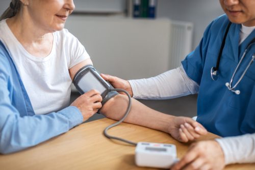 Healthcare provider checking patient's blood pressure.