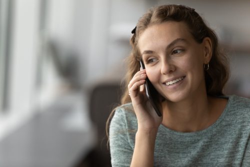 Smiling woman on cell phone calling for diabetes related supply reorder.